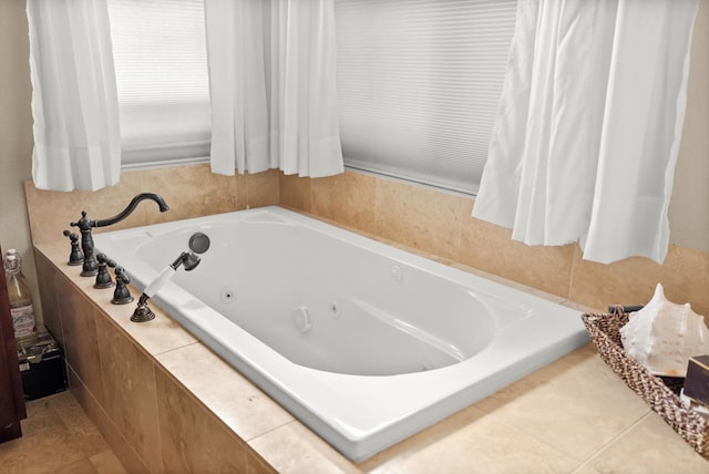 bathroom with tile patterned flooring and tiled bath