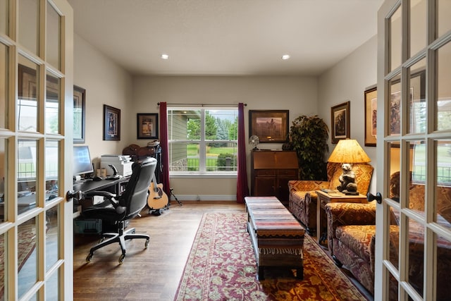 home office with hardwood / wood-style flooring and french doors