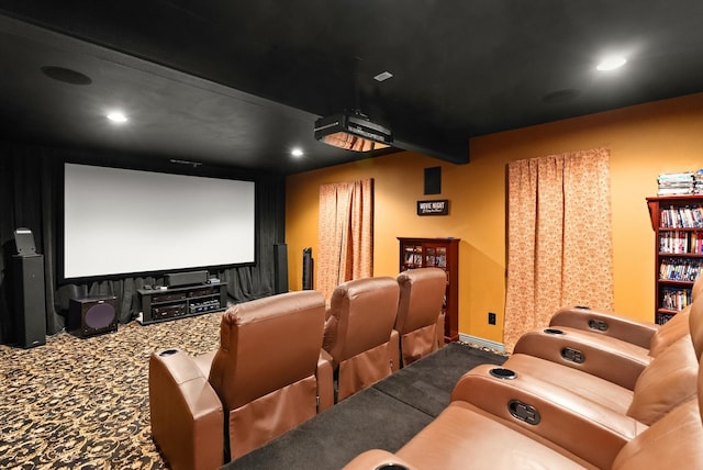 cinema room with carpet floors and beamed ceiling