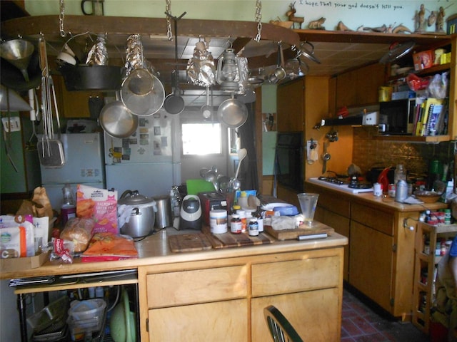 467 Cooper Ln, Hamilton, MT 59840 - kitchen featuring light countertops, under cabinet range hood, beverage cooler, and decorative backsplash