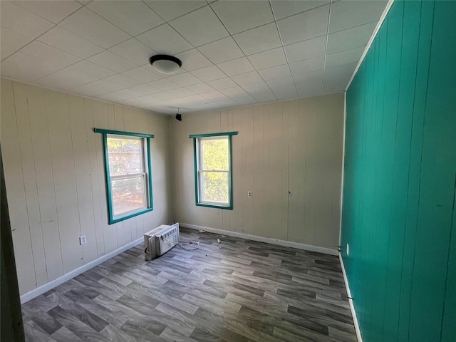 empty room with hardwood / wood-style floors and wood walls