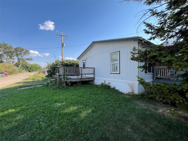 view of side of property with a deck and a lawn