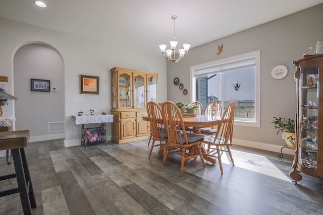 dining room featuring dark hardwood / wood-style floors and an inviting chandelier