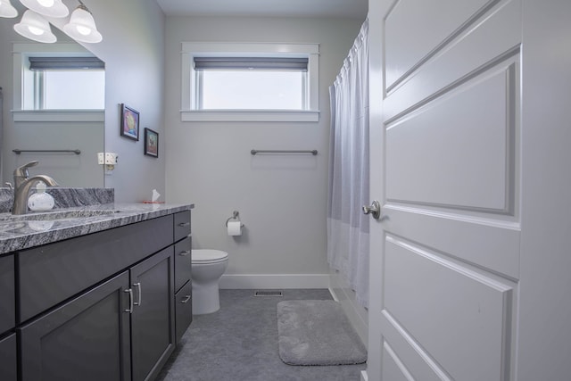 bathroom with a shower with curtain, vanity, toilet, and a wealth of natural light