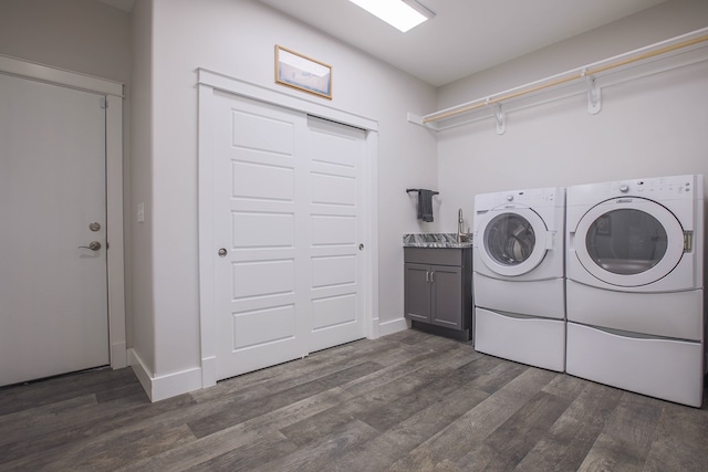 clothes washing area with cabinets, dark hardwood / wood-style flooring, and washer and clothes dryer