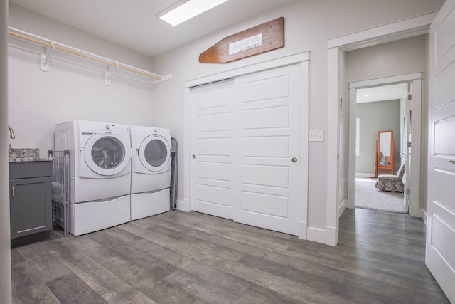 washroom featuring dark hardwood / wood-style flooring, cabinets, and washing machine and clothes dryer