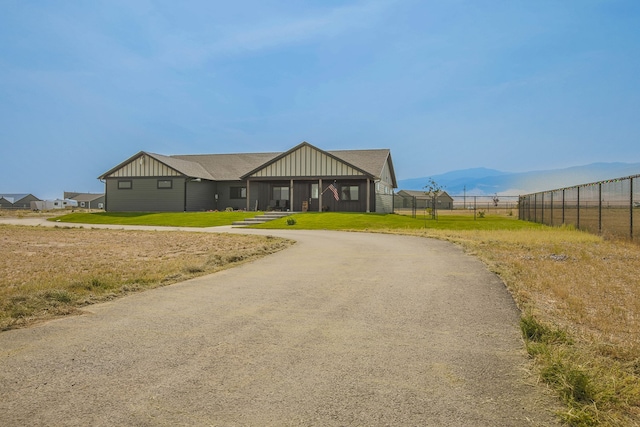 view of front of home with a front lawn and a mountain view