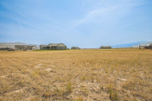 view of yard with a mountain view and a rural view