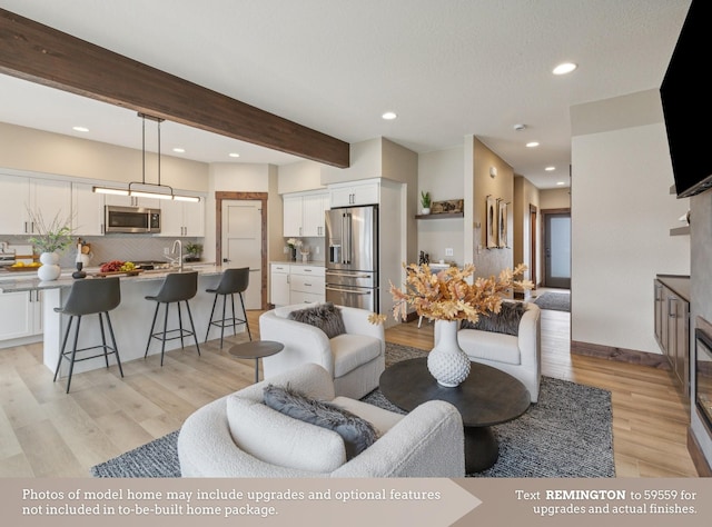 living room with light hardwood / wood-style flooring and beamed ceiling