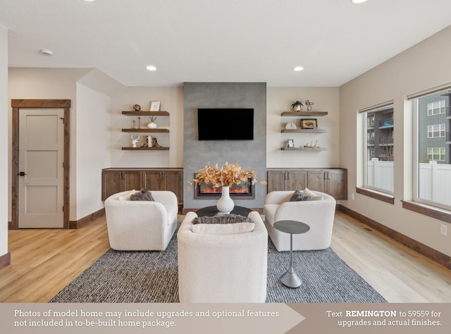 living room with a large fireplace and light hardwood / wood-style floors