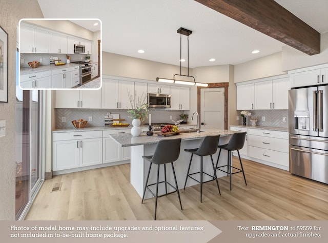 kitchen with white cabinets, beam ceiling, and stainless steel appliances