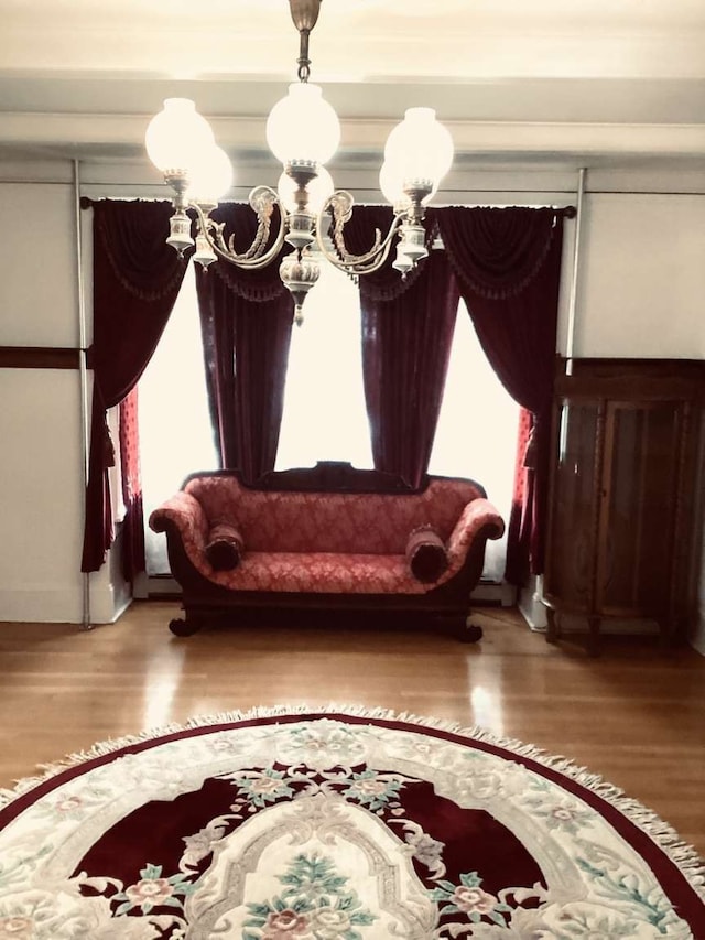 sitting room with wood-type flooring and a chandelier