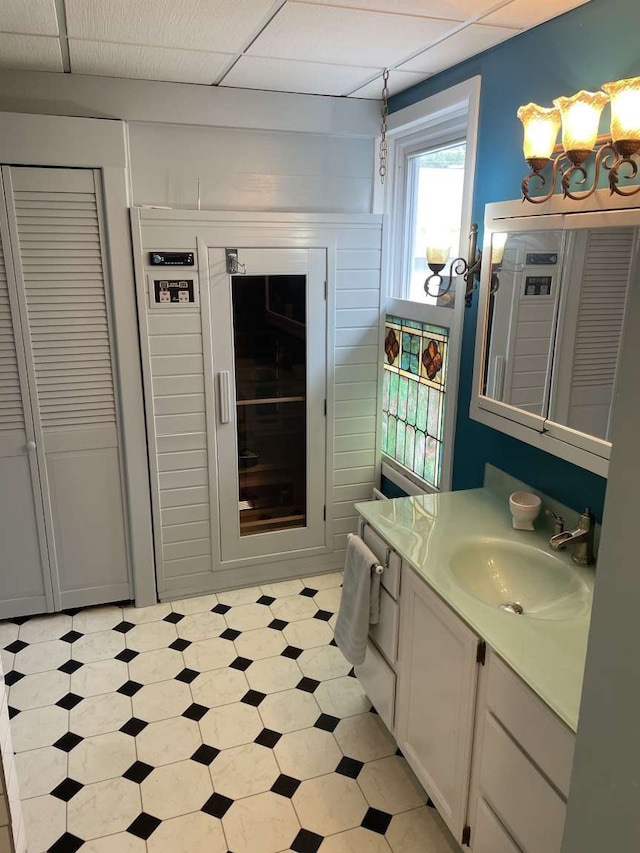 bathroom with a paneled ceiling and vanity