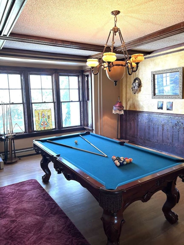 game room with ornamental molding, hardwood / wood-style flooring, a textured ceiling, and billiards