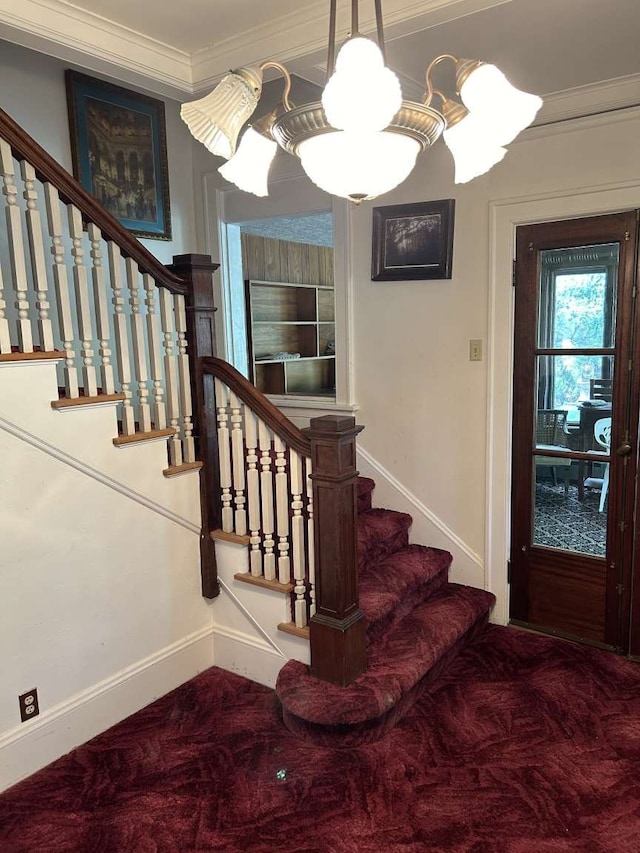 staircase with crown molding, a notable chandelier, and carpet flooring