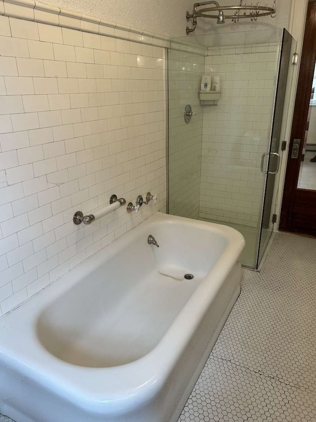 bathroom featuring tile patterned floors and shower with separate bathtub