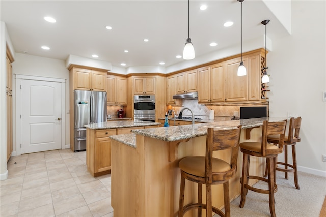 kitchen with light stone counters, stainless steel appliances, kitchen peninsula, light tile patterned flooring, and tasteful backsplash