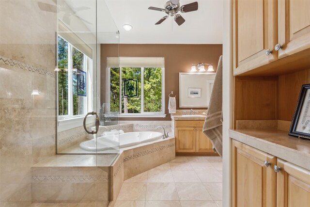 bathroom featuring tile patterned floors, ceiling fan, tiled tub, and vanity