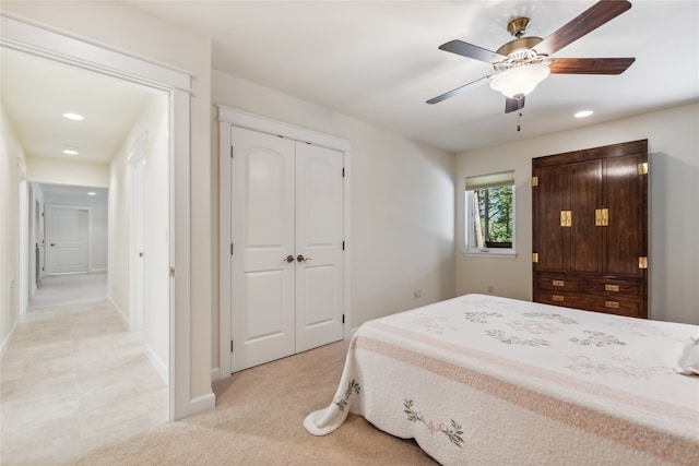 bedroom featuring light tile patterned floors, ceiling fan, and a closet