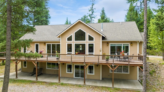 1550 Rolling Ridge Loop, Kalispell, MT 59901 - rear view of house featuring a patio area, a wooden deck, and a shingled roof