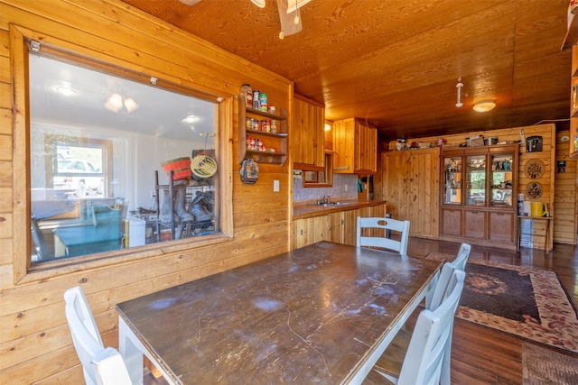 dining room featuring wood walls, sink, and wood-type flooring