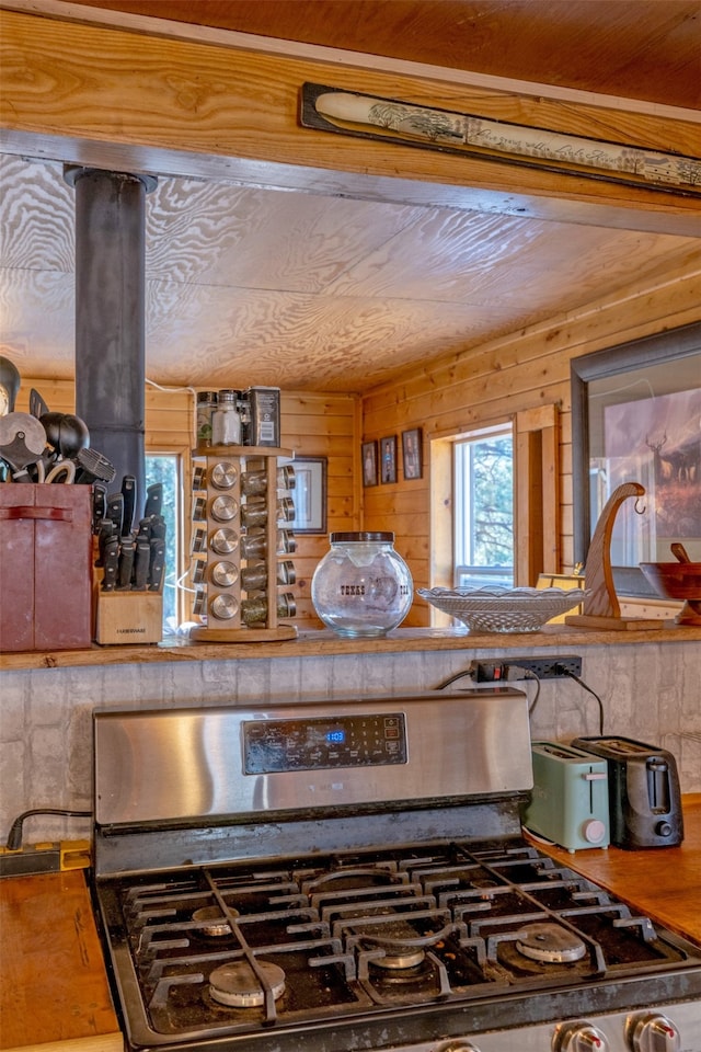 room details featuring wood walls and stainless steel gas range