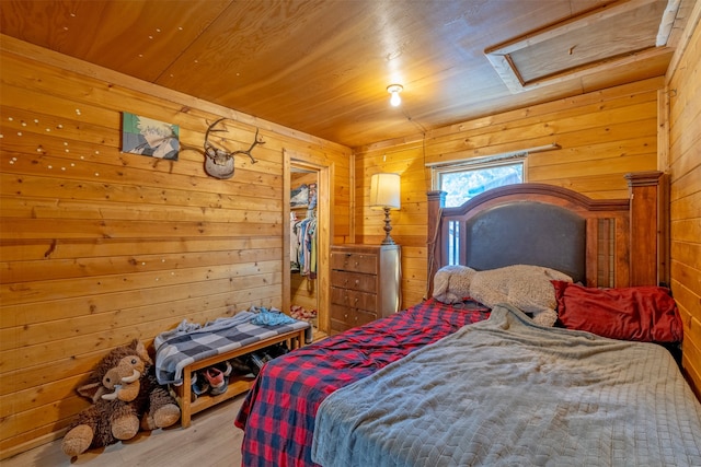 bedroom featuring wood ceiling, wooden walls, and light hardwood / wood-style floors