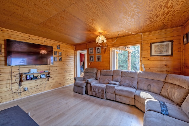 living room with light hardwood / wood-style floors, wood ceiling, and wood walls