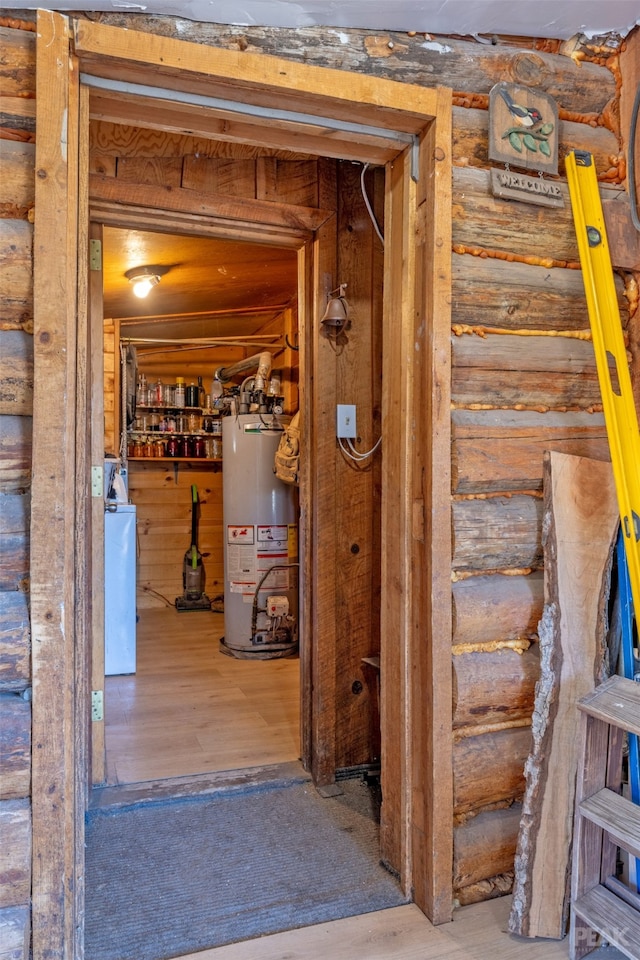 corridor with log walls, wood-type flooring, and water heater