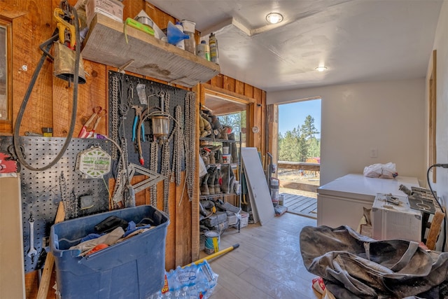 miscellaneous room featuring light hardwood / wood-style floors and wooden walls