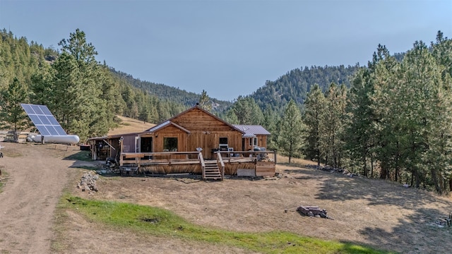 back of property featuring a mountain view and an outbuilding