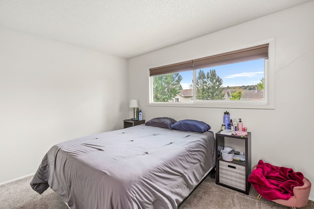 carpeted bedroom featuring baseboards and a textured ceiling