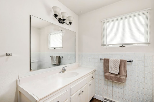 bathroom with a wainscoted wall, tile walls, and vanity