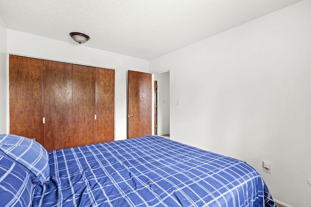 bedroom featuring a textured ceiling and a closet