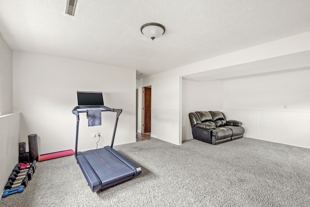 workout area with a textured ceiling, carpet, and visible vents