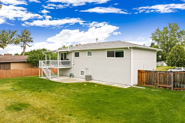 rear view of property featuring a lawn, a patio, stairs, fence, and a deck