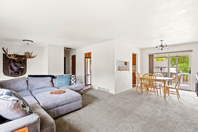 carpeted living room with visible vents and a notable chandelier