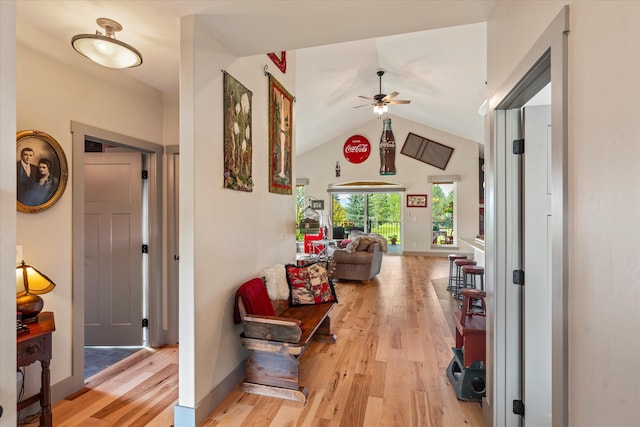 hallway featuring lofted ceiling and light hardwood / wood-style flooring