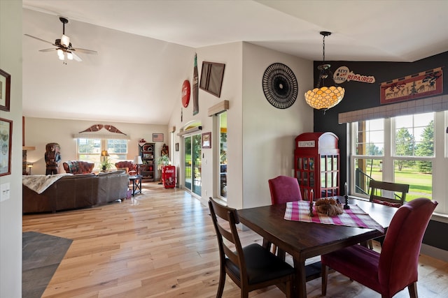 dining area with high vaulted ceiling, ceiling fan, and light hardwood / wood-style flooring