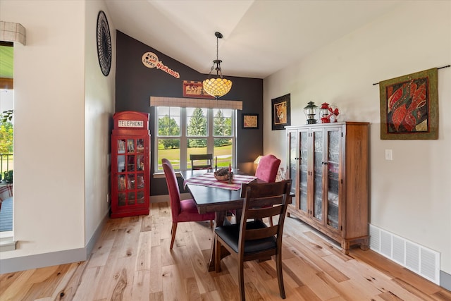 dining area featuring light hardwood / wood-style floors and vaulted ceiling