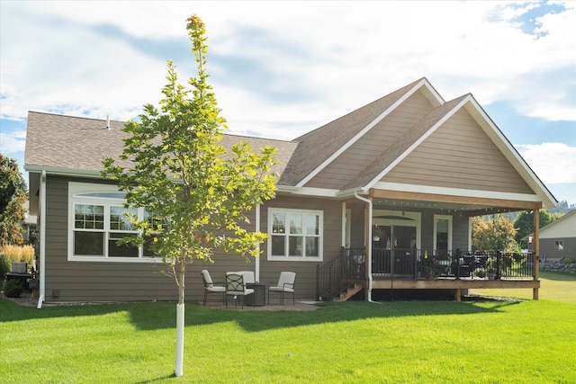 back of property with a yard and a wooden deck