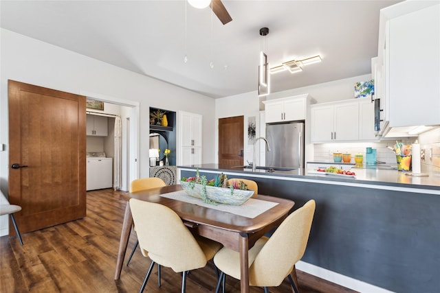 dining room featuring dark wood-style floors, ceiling fan, and washer / dryer