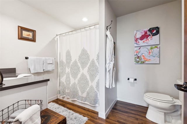 bathroom featuring baseboards, a shower with shower curtain, toilet, and wood finished floors