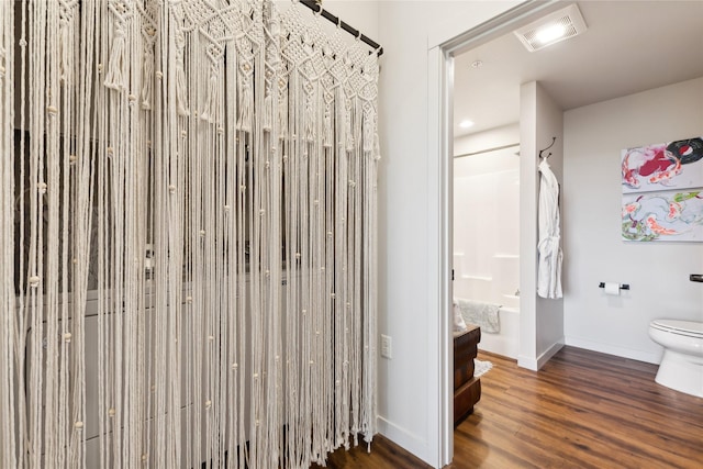 bathroom with shower / bath combination, visible vents, toilet, wood finished floors, and baseboards