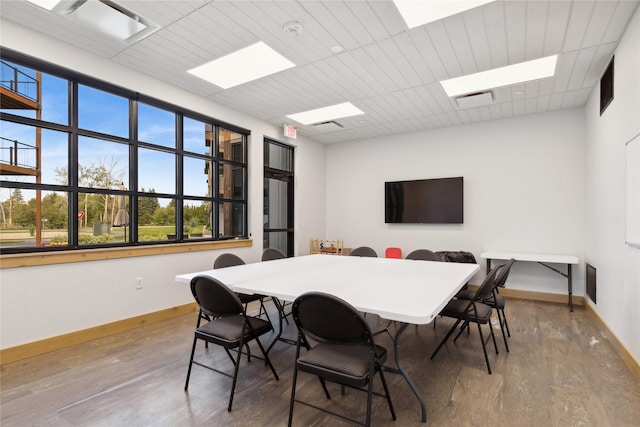 dining area featuring visible vents, a drop ceiling, baseboards, and wood finished floors