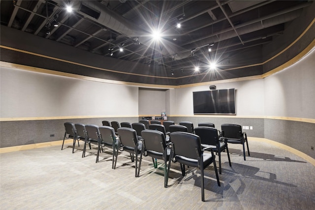 carpeted cinema featuring wainscoting and track lighting