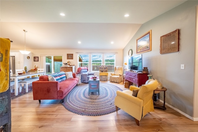 living room featuring light hardwood / wood-style floors and vaulted ceiling