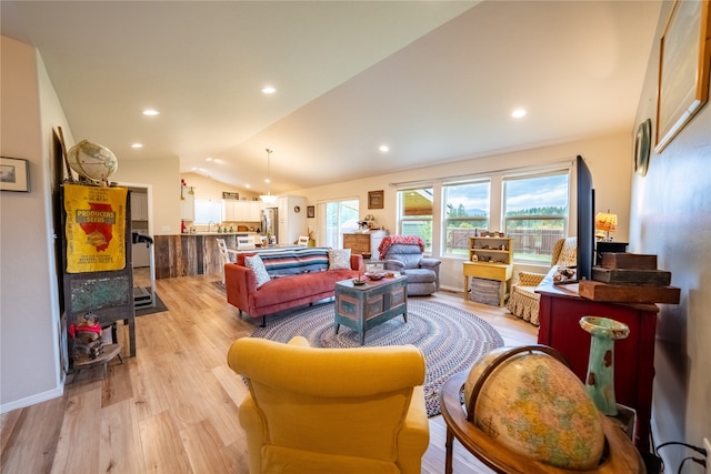 living room with lofted ceiling and light hardwood / wood-style flooring