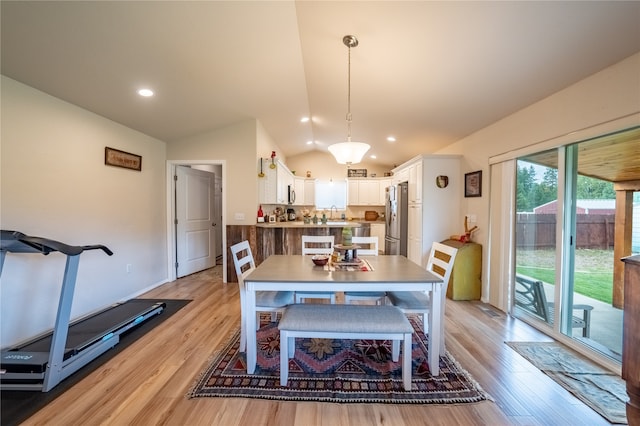 dining space with lofted ceiling and light hardwood / wood-style floors