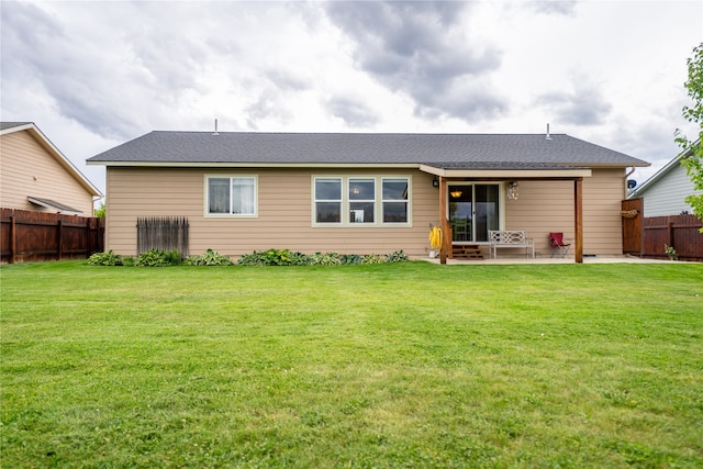 rear view of house with a yard and a patio